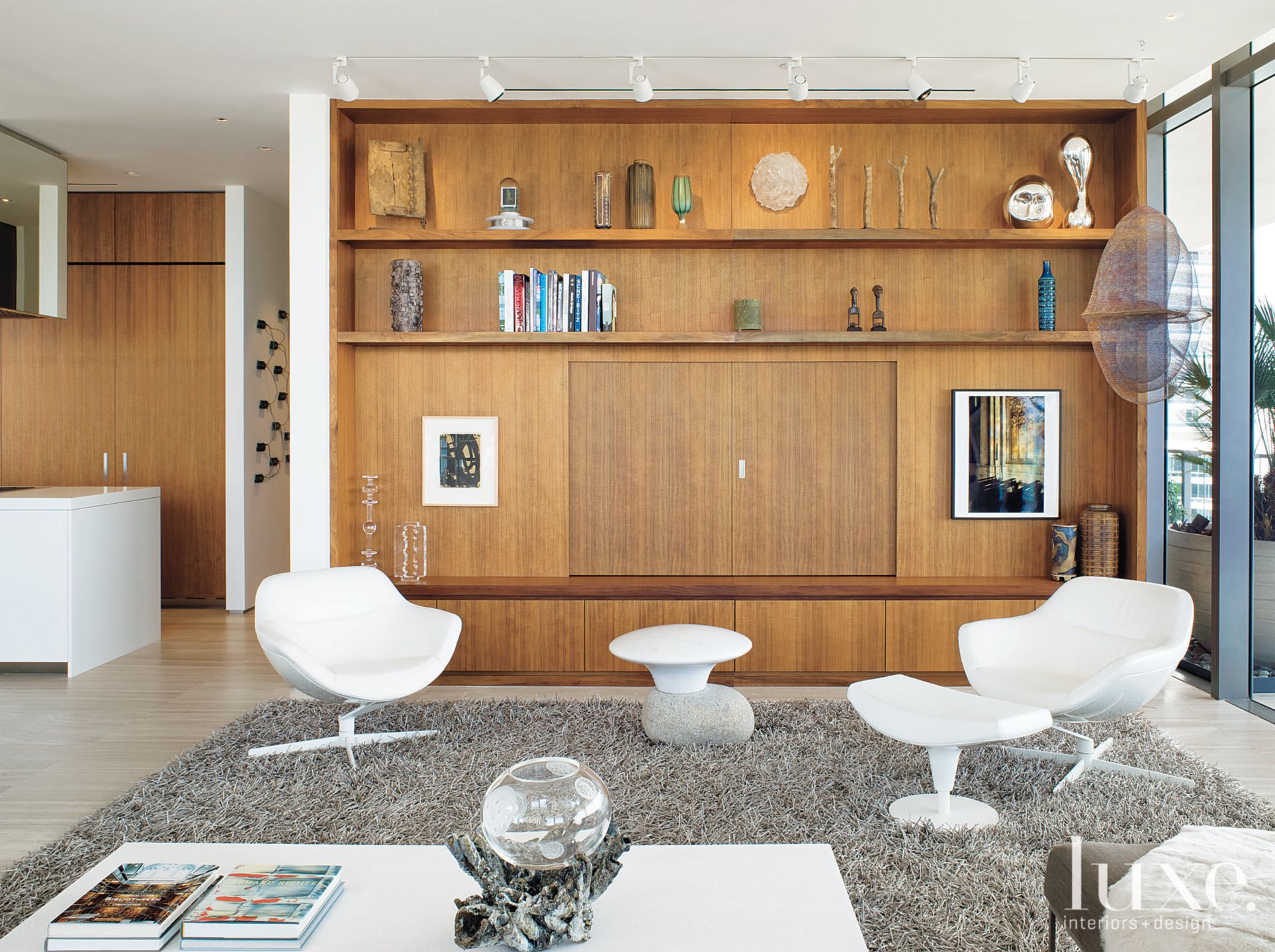 Living room with gray rug and arrangement of artwork Luxe Interiors